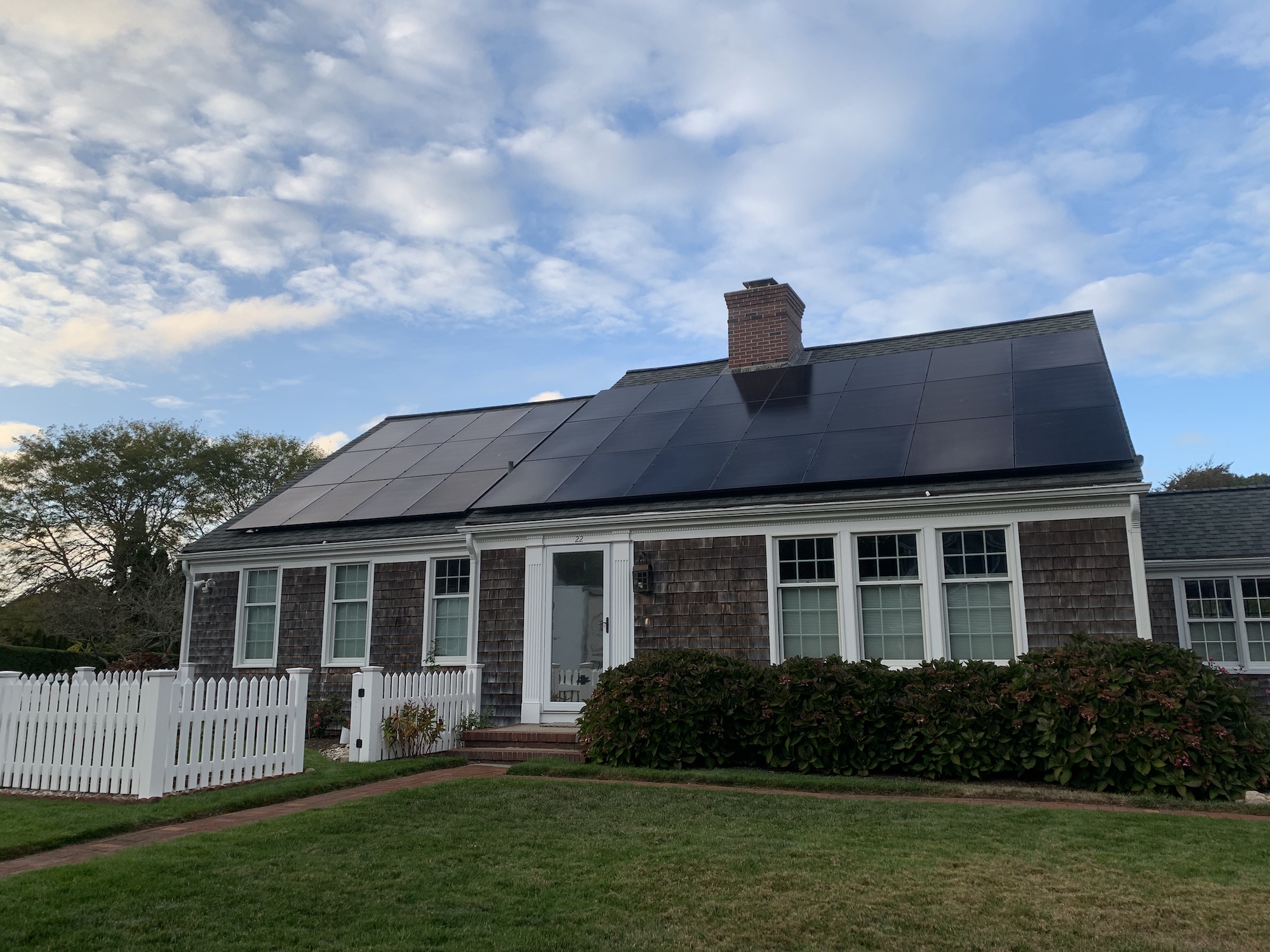 Cape Cod style home with solar panels covering the roof